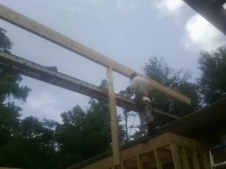 Carpenter setting a ridge beam over a new addition frame — Ice Dam Removal by Roofing Brothers in Beaver Dam