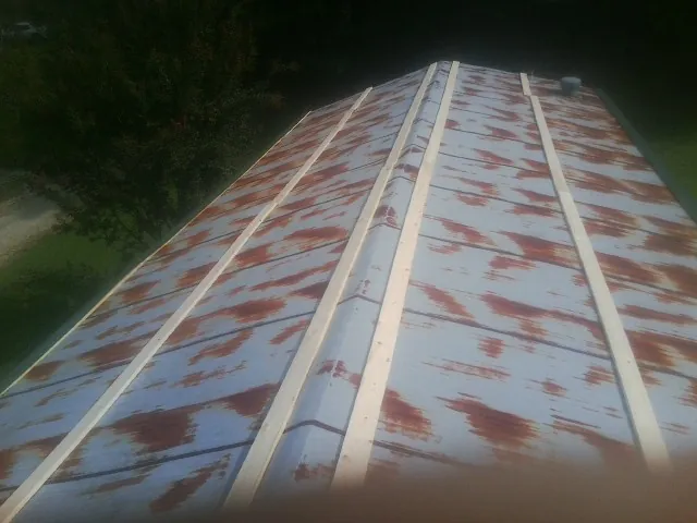 Rusted metal roof panels with new wood purlins before replacement — Storm Damage Roof Repair in Beaver Dam by Roofing Brothers
